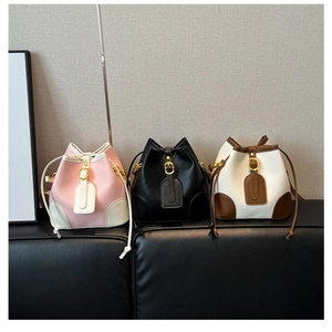 Three minimalist contrast bucket bags in pink, black, and brown with drawstring detail
