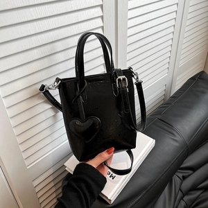 Minimalist black patent leather crossbody phone bag with heart charm and silver strap hooks