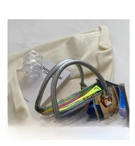 Macro shot of iridescent laser handbag featuring silver leather handle and metal lock detail