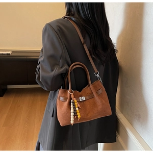 Sac seau en daim marron avec pendentif en perles, porté en bandoulière élégante