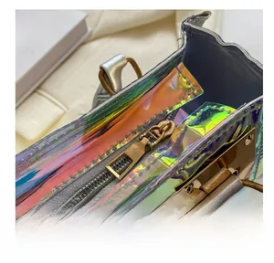 Macro detail of the smooth metal zipper and holographic PVC material on the square bag