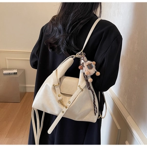 Model showing a cream leather tote bag with sheep charm and adjustable strap