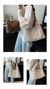 Detail of hand-woven straw tote bag with leather handles and pink heart charm