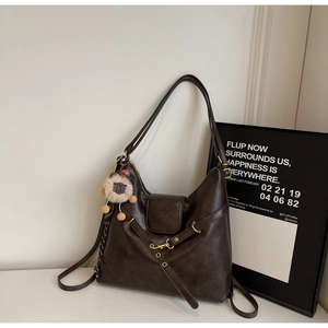 Detail of vintage brown tote bag with adjustable strap and cute sheep plush pendant