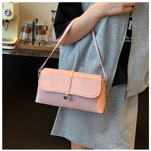 Détail du sac baguette en cuir verni rose avec boucle métallique G argentée