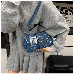 Model wearing a denim star shoulder bag with silver chain and vintage buckle detail