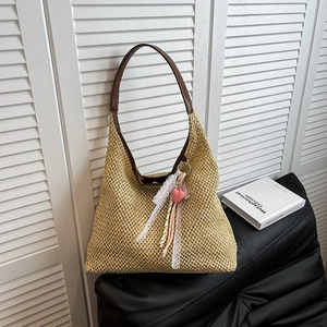 French straw woven bucket bag with brown leather straps and pink heart lace charm