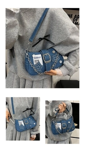 Detail of star denim underarm bag with metal chain and large decorative belt buckle strap