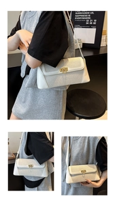 Detail of minimalist cream canvas and leather shoulder bag with golden metallic hardware