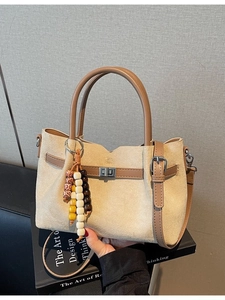 Sac seau en daim beige avec poignées en cuir marron et breloques en perles de bois