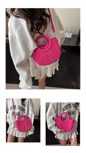 Detail of a bright fuchsia woven straw handbag with drawstring lining and crossbody strap