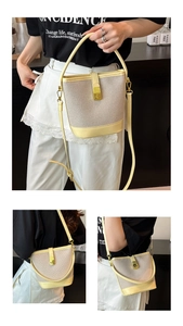 Detail of a contrast color woven bucket bag with leather handle and metallic CD buckle
