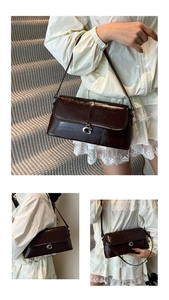 Détail d'un sac baguette en cuir marron foncé brillant avec boucle G en métal argenté