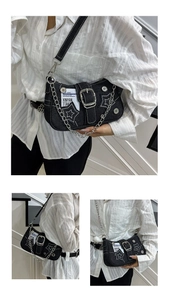 Detail of black denim bag with star embroidery, chunky metal chain and buckle strap
