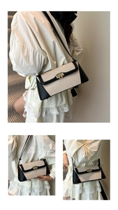Detailed close-up of a two-tone baguette bag featuring woven fabric and a gold turn-lock