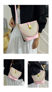 Macro detail of pink and beige canvas bucket bag with elegant gold clasp and handle