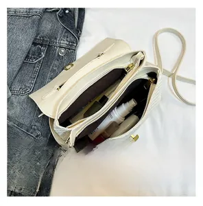 Top view of cream woven crossbody bag showing dual zipper compartments and interior space