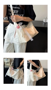 Detailansicht der weißen Halbmond-Tasche mit Spitzenschleifen und Herz-Anhänger