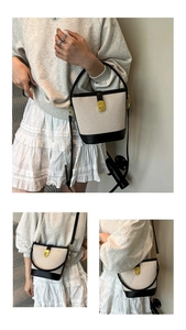 Detail of canvas bucket bag showing contrast leather trim and golden twist lock buckle