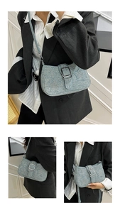 Detail of light blue denim shoulder bag with rhinestone stars and silver metal buckle
