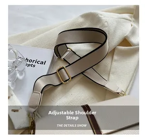 Détail de la large bandoulière en toile réglable avec ferrures dorées sur sac blanc