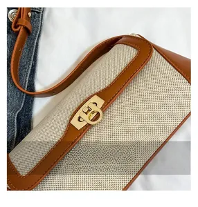Detailed close-up of the vintage canvas and brown leather stitching with gold metal buckle