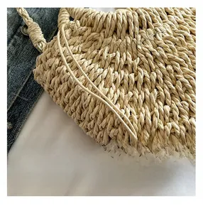 Close-up of beige handmade straw bag showing intricate cross-woven texture and drawstring