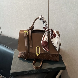Brown woven texture crossbody bag with silk scarf handle and golden twist lock