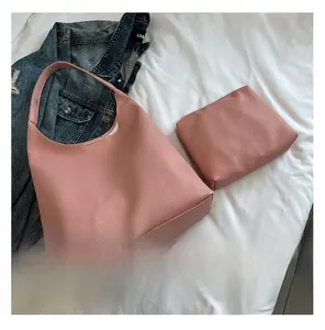 Detail view of pink lychee grain tote bag with matching zippered pouch on white sheets
