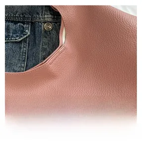 Close-up of pink litchi grain leather texture with neat stitching on a tote bag