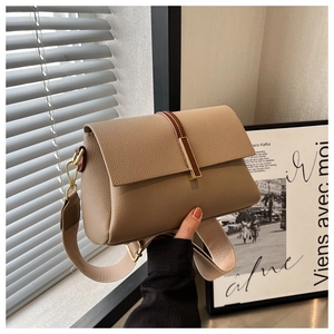 Détail du sac bandoulière en cuir grainé avec large sangle et boucle en métal doré