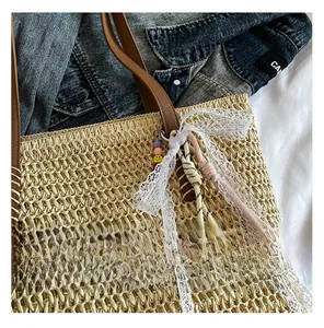 Detail of straw woven tote with leather handles, lace ribbons and smiley face charms