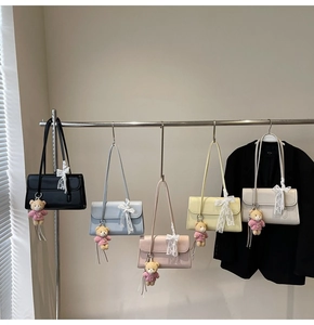Détail de sacs portés épaule en cuir PU en cinq couleurs avec des pendentifs en ours