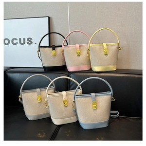 Detail showing various colors of contrast stitching canvas bucket bags on a sofa