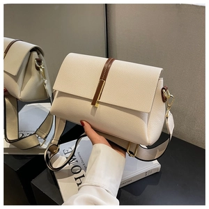 Gros plan d'un sac à main en cuir grainé blanc cassé avec détails dorés et bandoulière