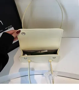 Vue détaillée de l'intérieur du grand sac à bandoulière en cuir crème avec compartiments
