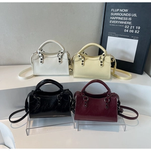 Détail de sacs à main carrés élégants en blanc, beige, noir et bordeaux avec rivets