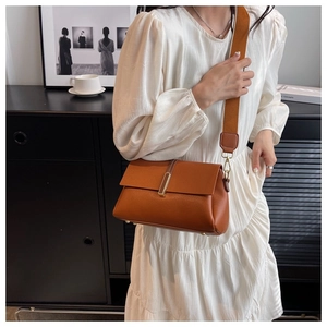 Sac bandoulière en cuir marron avec large sangle et boucle métallique dorée détail
