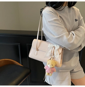 Sac sous le bras rose pâle avec nœud en dentelle, pendentif ours et cuir brillant
