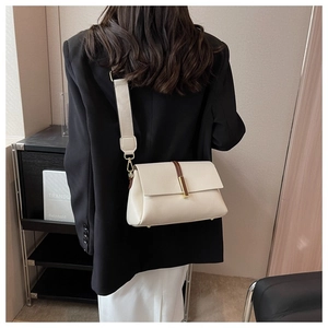 Détail du petit sac blanc cassé avec bandoulière contrastée et boucle dorée sur modèle