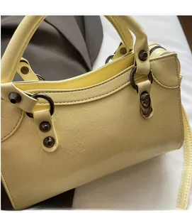 Détails du sac à main en cuir texturé jaune pâle avec rivets et anneaux en métal