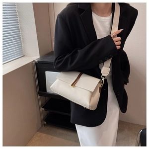 Détail du sac bandoulière crème avec sangle en cuir et ferrures dorées sur mannequin