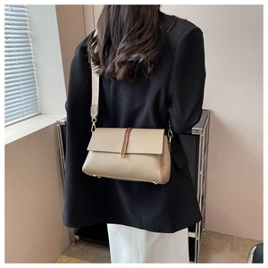 Vue détaillée du sac bandoulière en cuir kaki avec bandoulière large et boucles dorées