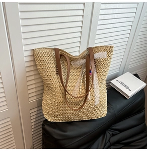Detail of woven straw tote bag with brown leather handles and lace bow charm