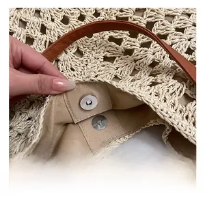 Detail of straw tote bag showing internal lining and magnetic snap metal closure