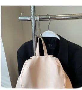 Detail of a minimalist light pink backpack with sturdy top handle and smooth zipper closure