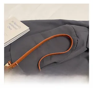Close-up of brown faux leather handle and hollow out straw weave on summer tote bag