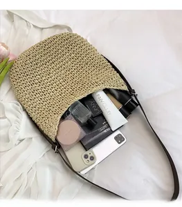 Detail view of woven straw bucket bag showing spacious interior with daily essentials