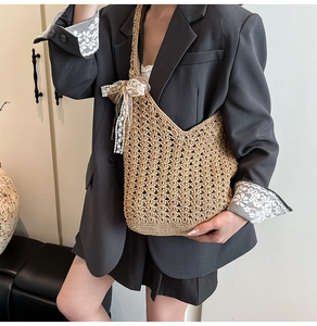 Détail du sac fourre-tout en paille tressée avec nœud en dentelle blanche et perles