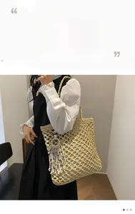 Detail of beige hollow woven tote bag featuring cotton rope mesh and decorative tassel
